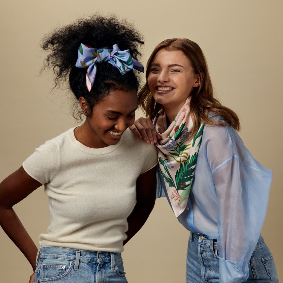 one model wearing the floral scarf as a headband and the other as a scarf