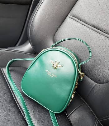 reviewer image of the green crossbody bag on the passenger seat of a car