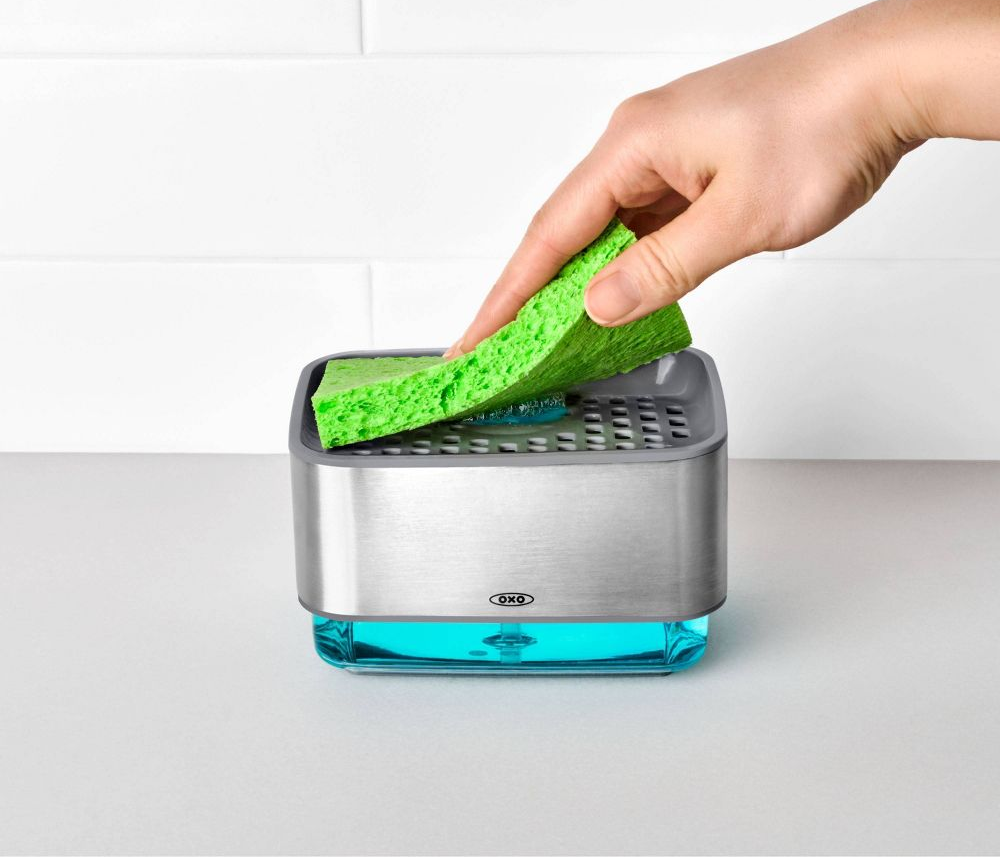 someone pressing down on a sponge to dispense the soap onto it