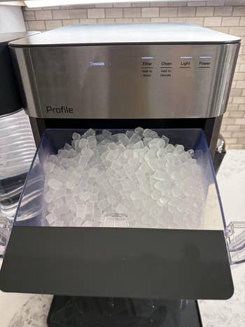 Ice shaper with tray filled with nugget ice, acceptable connected a room countertop
