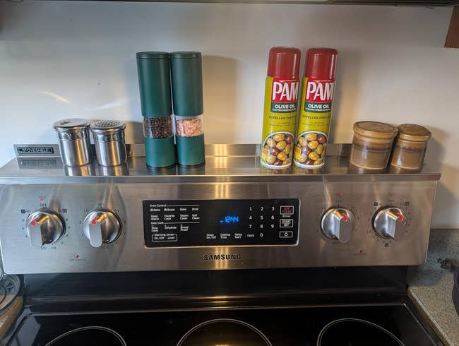 Stainless alloy  stove power  sheet  with assorted  seasonings, PAM spray cans, spice grinders, and brackish  and capsicum  shakers connected  top