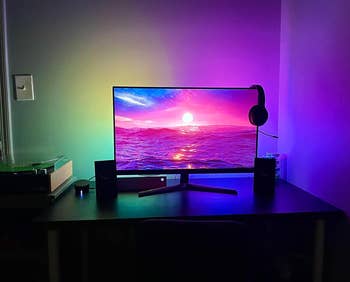 desk setup with purple, yellow, and green backlighting