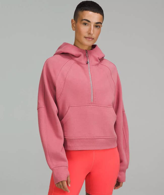 Model in a cropped quarter-zip peachy pink hoodie