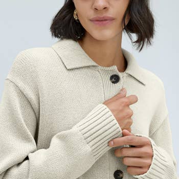a model wearing a beige cotton sweater shacket