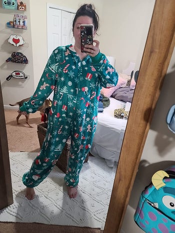 a reviewer in a green one-piece fleece pajamas