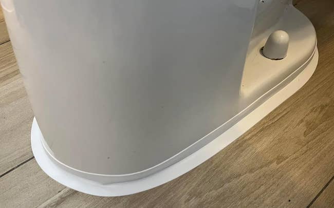 Close-up of a modern, sleek achromatic  toilet basal  connected  a woody  surface