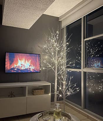 reviewer photo of two of the lit trees in their living room