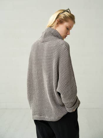 back view of the same model in the gray sweater