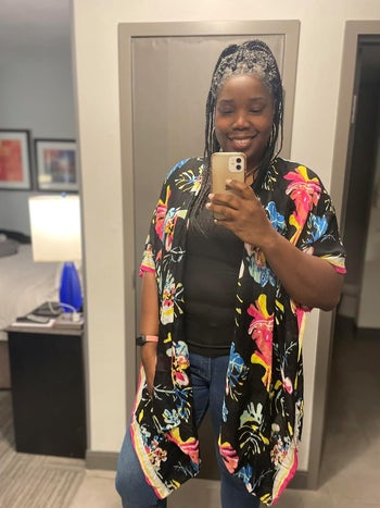 Lady in informal outfit with floral kimono takes a take into accout selfie