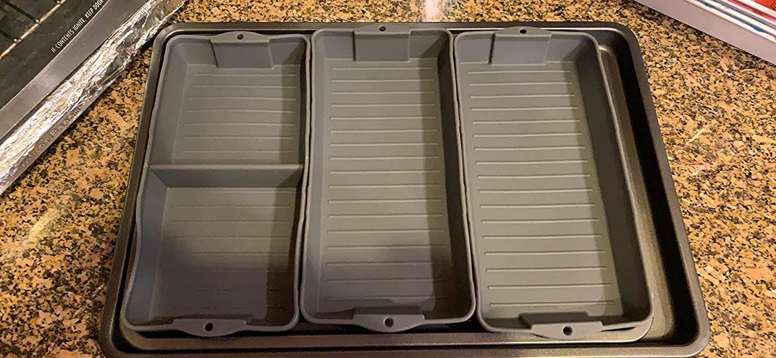 reviewer photo of three silicone dividers on a baking sheet