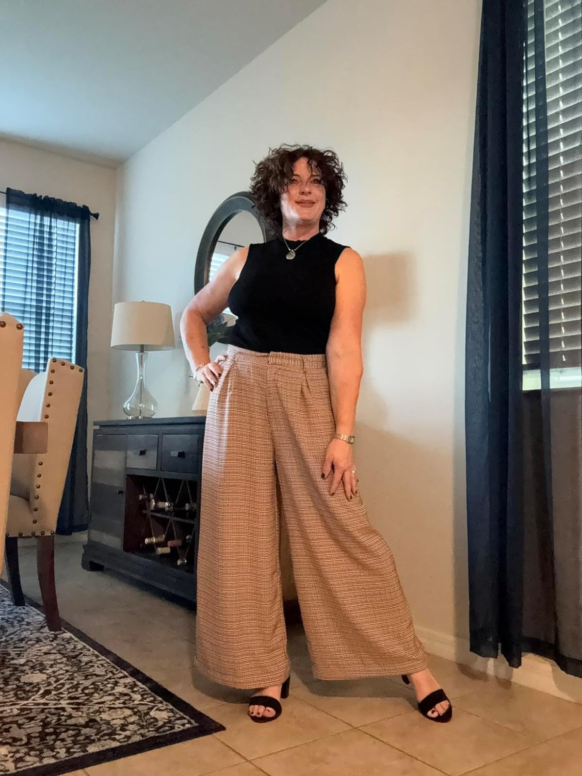 Reviewer in wide-leg trousers and a black top