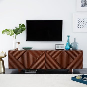 The credenza underneath a TV in walnut