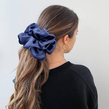 model wearing the big blue scrunchie in their hair as a ponytail