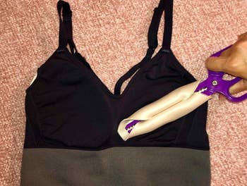 Model holding purple scissor with bra pad wrapped around it 