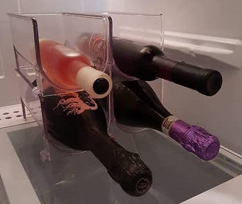 Reviewer image of four clear wine holders with bottles