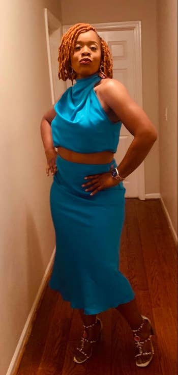 Reviewer in a two-piece blue outfit with a halter top and ruffled skirt
