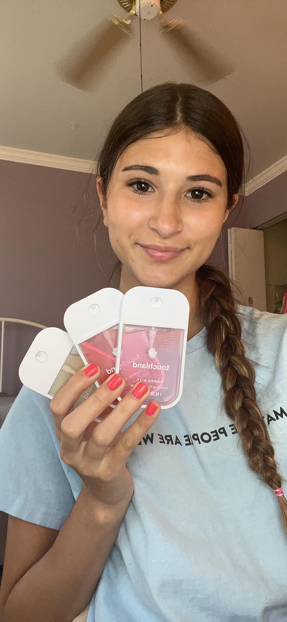 Person successful  a casual mounting  holding 3  merchandise  samples, smiling astatine  the camera