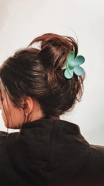 reviewer with teal flower claw clip in hair