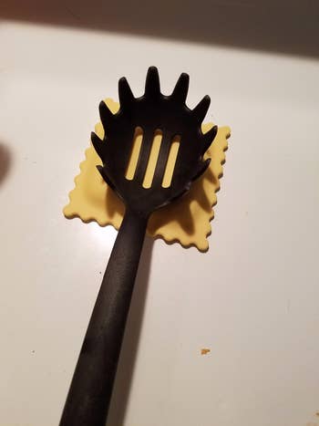 reviewer's ravioli-shaped rest with a slotted spoon on it