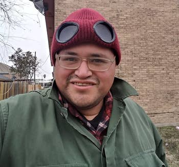Reviewer wearing red knit beanie with built-in black goggles with green jacket