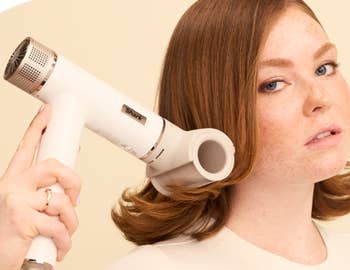 a model using the blow dryer with round attachment to do their hair