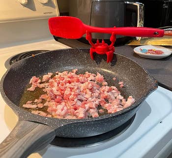 crab holding spatula connected pan