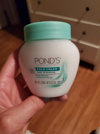 reviewer holding jar of the cleanser