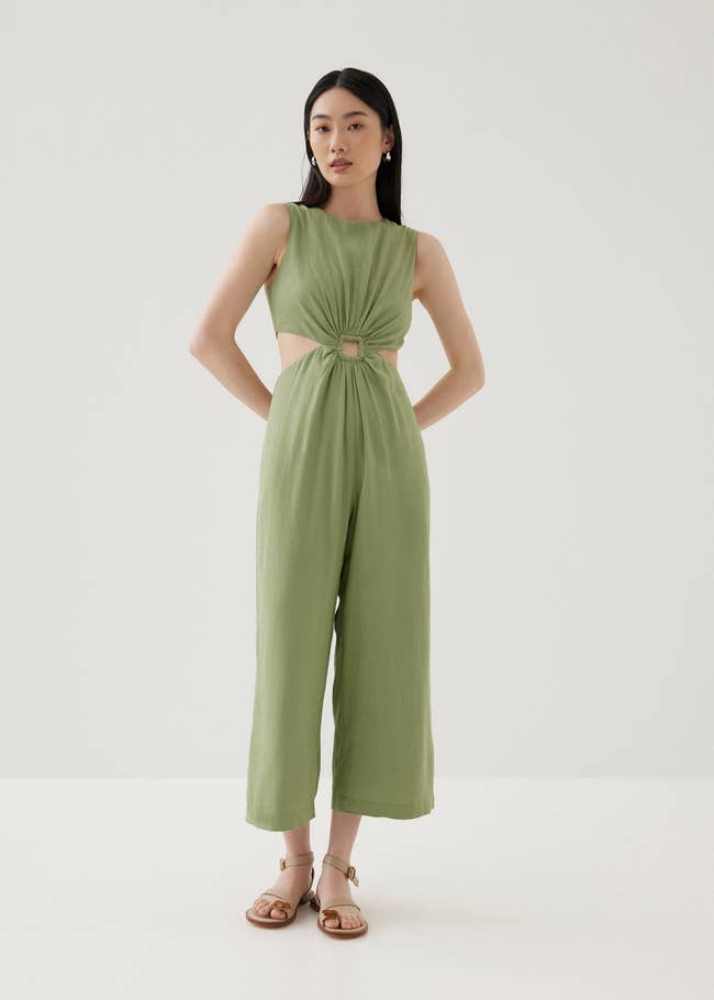 Model in the jumpsuit with open buckle detailing and size cutouts at the waist
