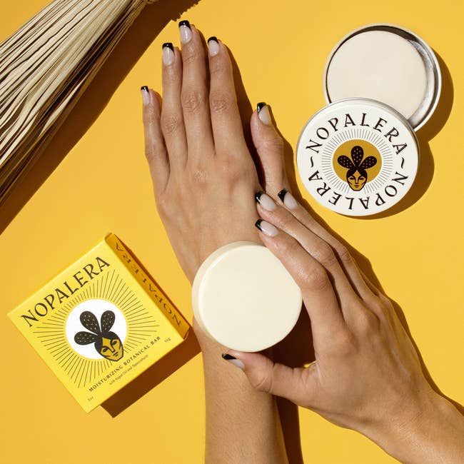 A model using the Nopalera moisturizing bar on their arm with another moisturizing bar next to their hand