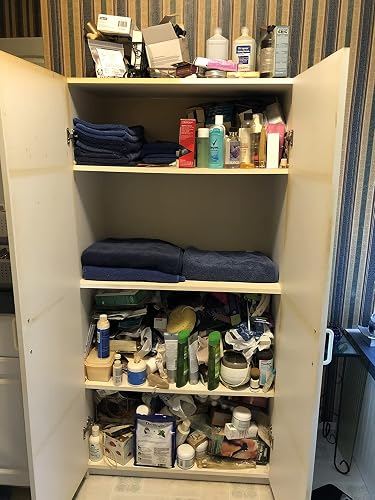 Bathroom furniture  filled with toiletries, towels, and assorted  idiosyncratic   attraction   products organized connected  shelves