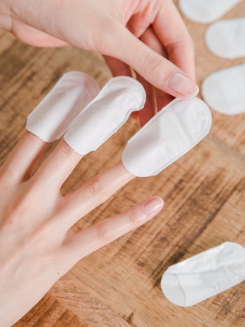 model putting the nail wraps on fingers