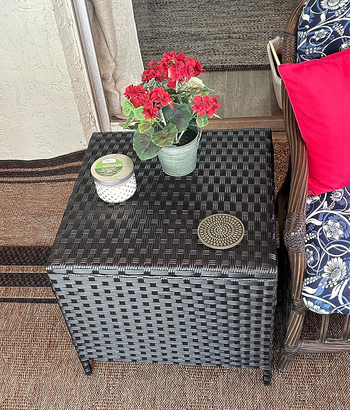 reviewer's black end table with flowers and a candle on it