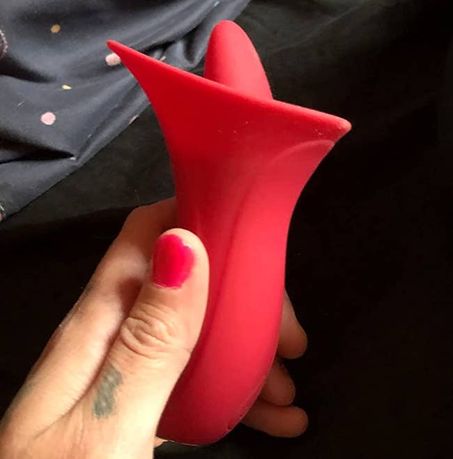 Reviewer holding red licking vibrator