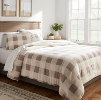 the comforter & sham set in gray/cream on a bed with white sheets