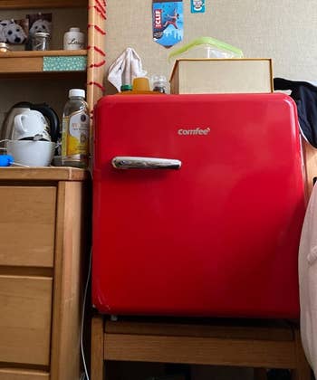 Reviewer image of red retro mini fridge on top of chair next to wooden desk