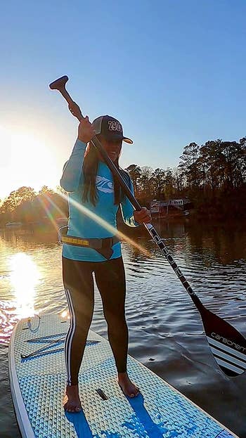 reviewer wearing a rash guard while paddle boarding