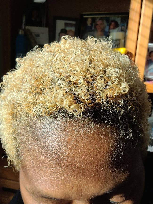 close up image of a reviewer with shiny, short blonde coils