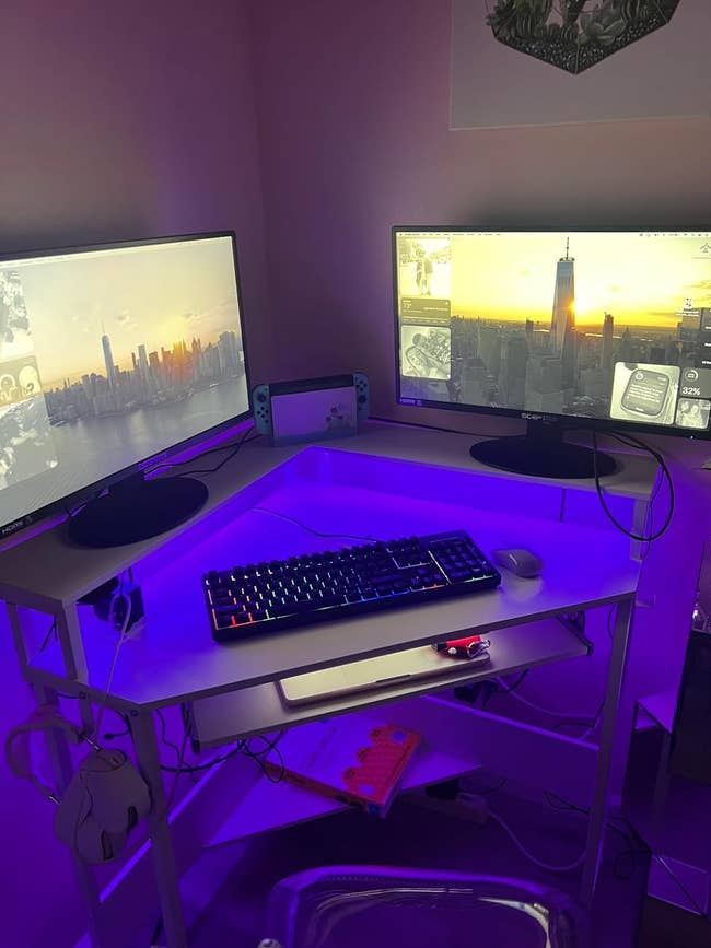 a reviewer's desk with purple lights and two monitors on top