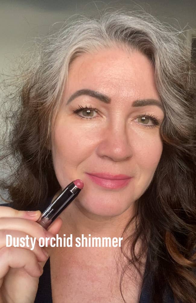 reviewer with the lip balm in the dusty orchid shimmer shade on their lips