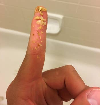 reviewer with removed ear wax bits on finger