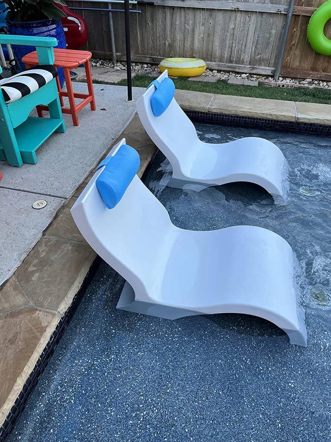 a reviewer's two white pool chairs with blue headrests