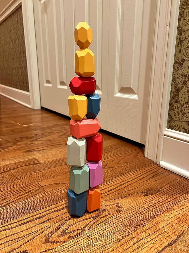 Stacked woody artifact toys lasting connected a woody level successful beforehand of a achromatic door, showcasing equilibrium and creativity