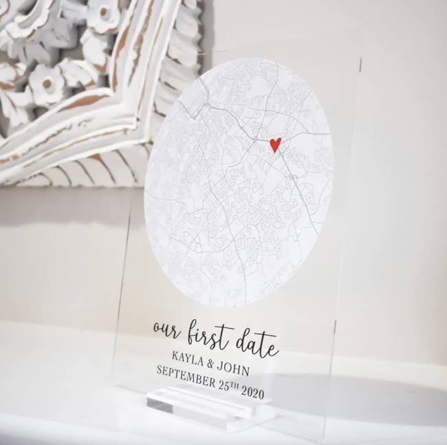 acrylic sign with map image marked with a heart and the words our first date with names and date of event
