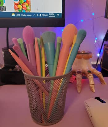 Makeup brushes in various pastel colors in a cup 