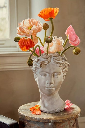 flowers coming out of the top of the bust pot