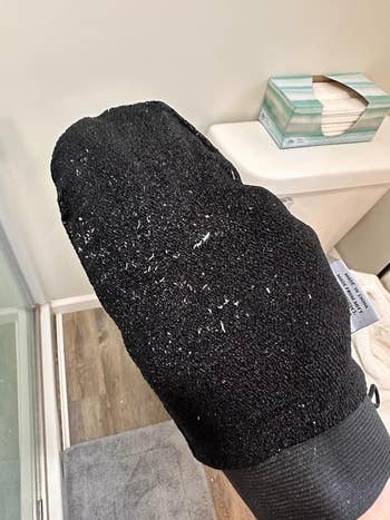the black fingerless mitt with gross bits of white exfoliated skin all over it