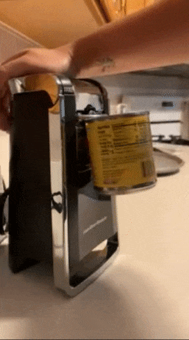 reviewer using electric can opener to open a can
