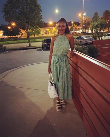 A reviewer wearing the mid calf length dress in light green with white polka dots