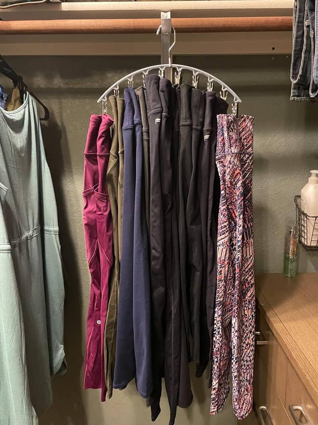 Assorted leggings hanging from a leggings hanger in a closet