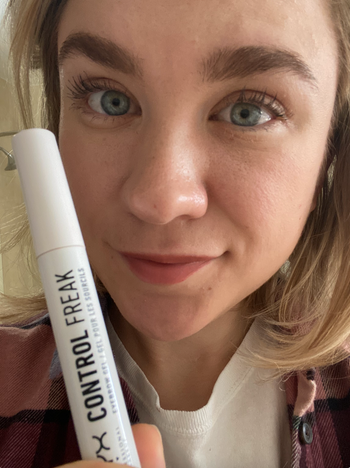 BuzzFeed editor with shaped brows holding tube of eyebrow gel 
